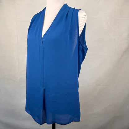A sleeveless blue V-neck blouse displayed on a white mannequin torso against a light gray fabric backdrop.
